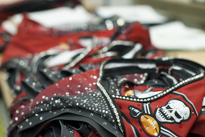 The Line Up - Tampa Bay Buccaneer Cheerleaders Signature Costume - Applying rhinestones to the costume