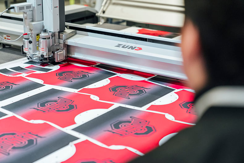 cutting pieces for the The Ohio State University custom pom uniform